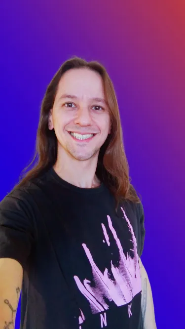 Picture of the author smiling with a blue and purple background